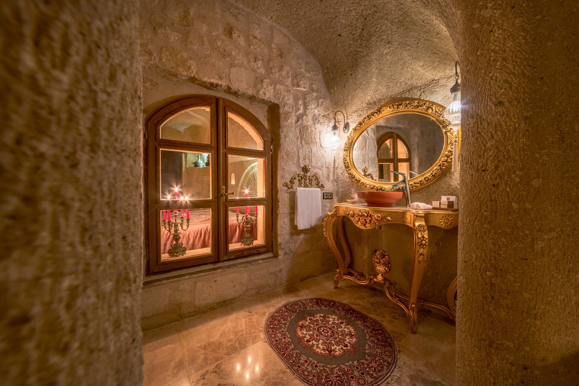 Taş kemerli mağara otel banyosunda aynalı lavabo ve aydınlatma