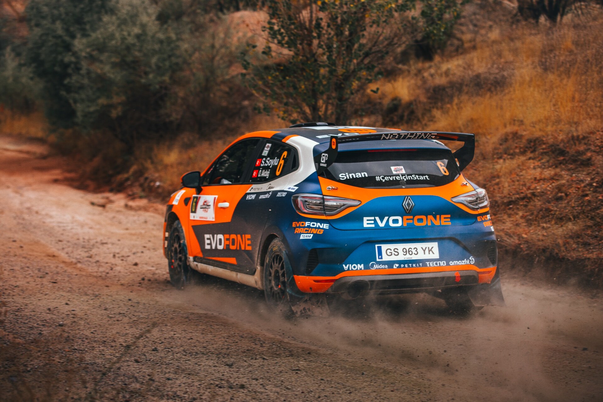 Sponsor logolu ralli otomobilinin toprak parkurdaki marka ve etkinlik fotoğrafı