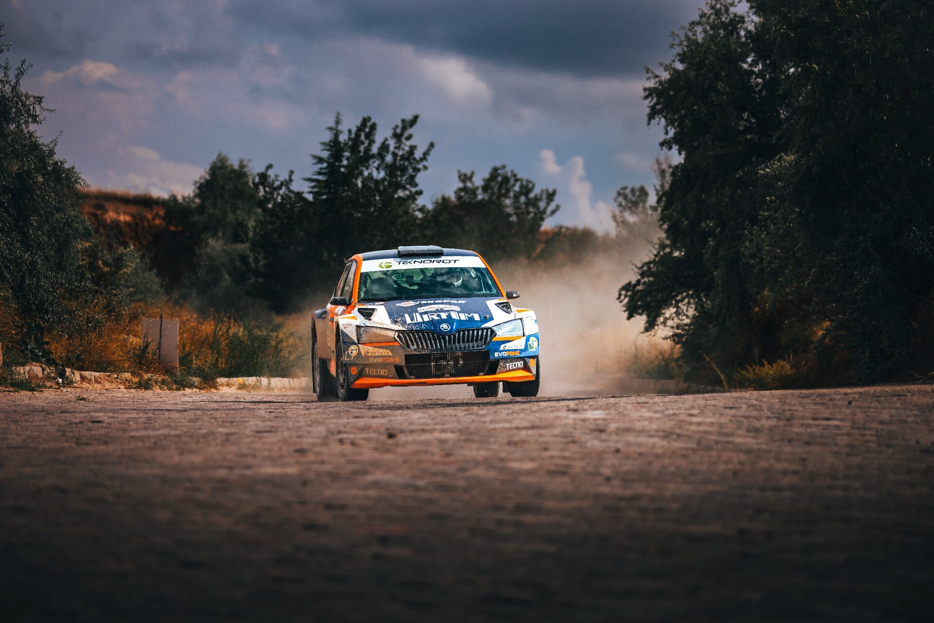 Ralli otomobilinin tozlu parkurda önden çekilmiş motorsporları fotoğrafı