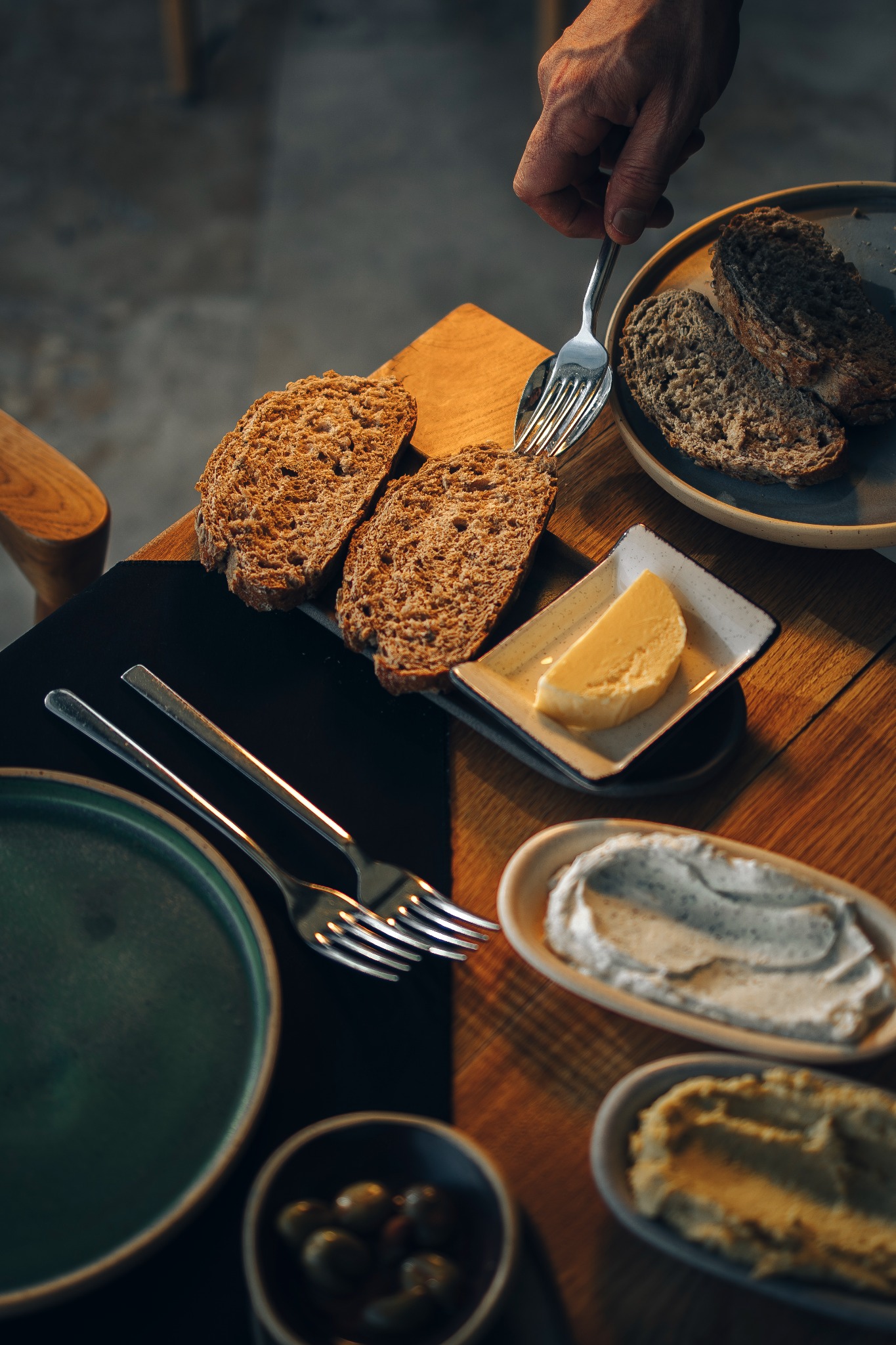 Rustik masada ekmek, tereyağı ve kahvaltı servisinin üstten fotoğrafı